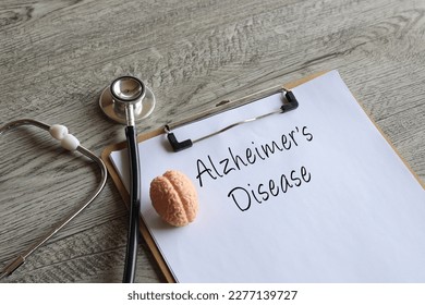 Stethoscope, human brain model and paper clipboard with text Alzheimer's Disease. Medical and healthcare concept
