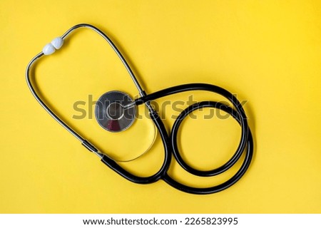 Stethoscope isolated on yellow background. Top view. Selective focus
