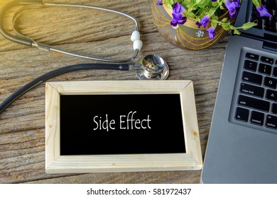 Stethoscope, laptop and flower on wooden table with SIDE EFFECT word as medical concept