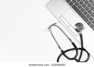 Stethoscope and laptop keyboard on white background, top view with copy space - Powered by Shutterstock