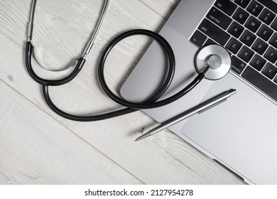 Stethoscope, laptop keyboard and pen on wooden background. Top view. Flat lay. - Powered by Shutterstock