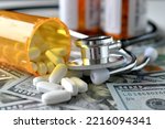 Stethoscope laying on medicine white pills  money with RX prescription drug bottle HSA FSA costs