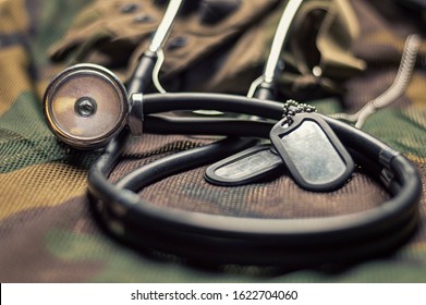 Stethoscope Lies On The Uniform Of A US Soldier. The Concept Of Health Care, Military Insurance, State Care. Top View. Mixed Media