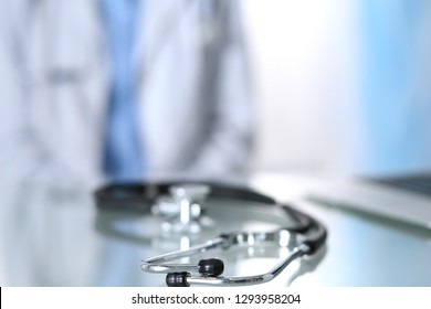 Stethoscope lying on glass desk with laptop computer at busy physician background. Medicine or pharmacy concept. Medical tools at doctor working table - Shutterstock ID 1293958204