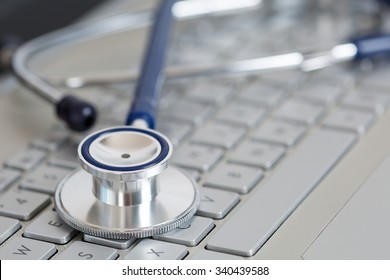 Stethoscope Lying On Laptop Keyboard Closeup. Medical Concept. Modern Medicine And High Tech Equipment Concept