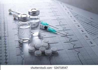 Stethoscope Medical Ampules Pills And Syringe On EKG Graph Background