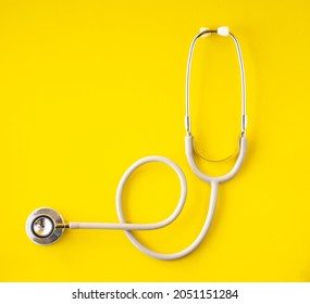 stethoscope medical features  health care  heart care above yellow background  top view