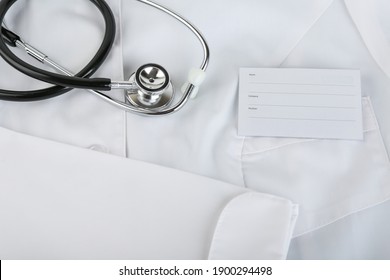 Stethoscope And Medical Gown With Name Badge Top View 