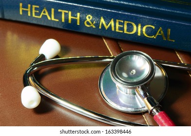 Stethoscope And Medical Text Book On The Doctor's Desk.