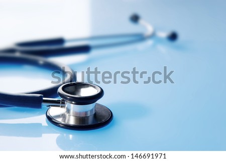 Stethoscope on blue, reflective background 