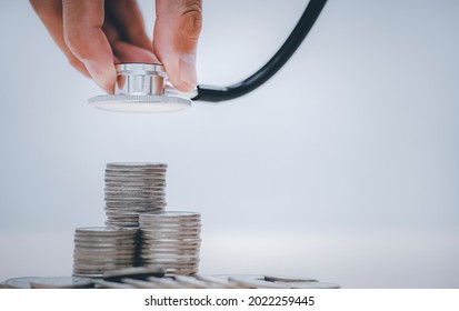 Stethoscope on coin stack on white background, stethoscope checking stack of money coins arranged as a graph on wooden table,saving and manage money for healthcare, life insurance business technology, - Powered by Shutterstock