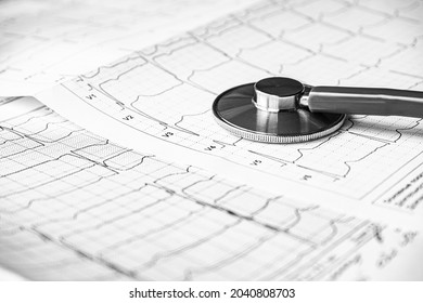 Stethoscope on the electrocardiogram (ECG) graph (top view). EKG printout with stethoscope. Medical health concept. Auscultation, listening to the heart pulse with a stethoscope