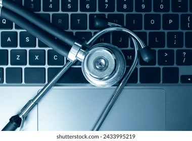 Stethoscope on laptop keyboard depicting healthcare technology