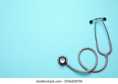 Stethoscope on light background, top view. Space for text