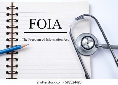 Stethoscope on notebook and pencil with FOIA (The Freedom of Information Act) words as medical concept.