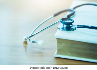 Stethoscope On An Old Textbook On Doctor's Table Or Office, Medical Class Or Knowledge. 