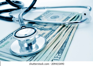 a stethoscope on a pile of US dollar bills, depicting the health care industry concept