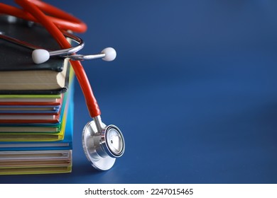 stethoscope on stack of medical guide book for doctor learning treatment hospital. - Shutterstock ID 2247015465