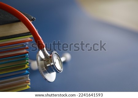stethoscope on stack of medical guide book for doctor learning treatment hospital.
