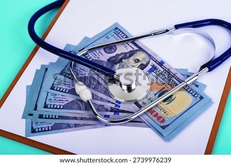 Stethoscope on stack of US hundred dollar bills. Concept for high medical costs, healthcare insurance, and financial expense in the medicine industry.
