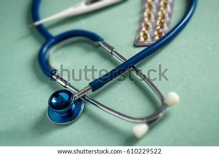 A stethoscope on a textured background,pills, thermometer blur background