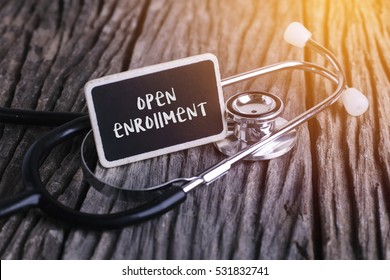 Stethoscope on wood with open enrollment word as medical concept