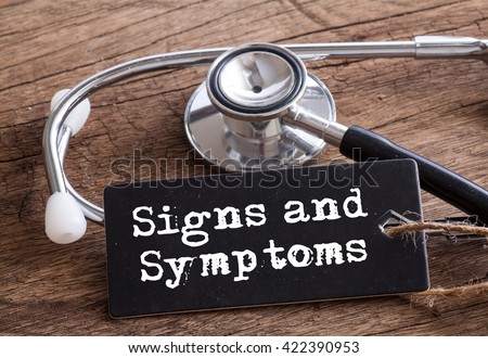 Stethoscope on wood with Signs and Symptoms words as medical concept