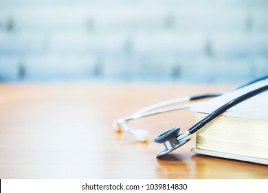 Stethoscope over big hand book    on doctor desk in hospital , medical class or knowledge background with copy space.