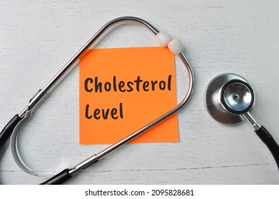 Stethoscope and paper note with text CHOLESTEROL LEVEL. Health concept