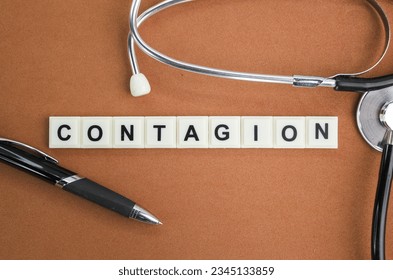 stethoscope and pen with the alphabet word Contagion. concept of disease and medicine
