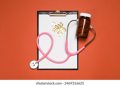 Stethoscope, pills and clipboard on crimson background, flat lay. Medical tool Stock-foto