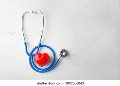 Stethoscope And Red Heart On White Wooden Background. Health Care Concept