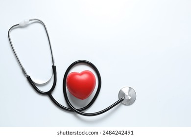 Stethoscope with red heart on white background, top view