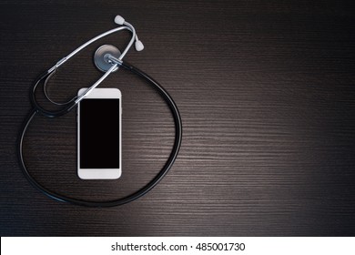 Stethoscope With Smart Phone On Wooden Table