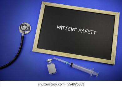 Stethoscope, syringe, medication ampule and Chalk board with description patient safety on blue background. Medical concept.