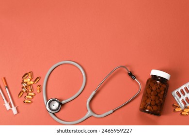 Стоковая фотография: Stethoscope, syringes and pills on crimson background, flat lay. Space for text