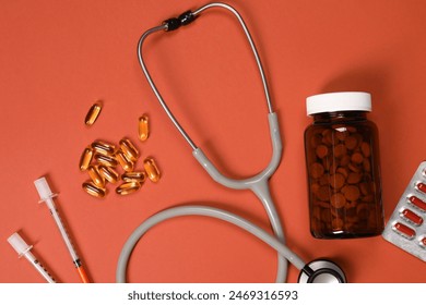 Stethoscope, syringes and pills on crimson background, flat lay. Medical tools Stock-foto