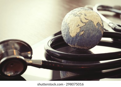 stethoscope and texture globe with digital tablet as medical network concept