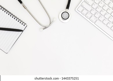 Stethoscope, Top View Of Doctor's Desk White Table, Laptop On White Background, Above View Doctor Work Tools On White Background, Medical Equipment On White Background With Laptop For Background.