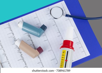 Stethoscope With Two Asthma Inhalers And A Peak Flow Meter On A Medical Clipboard