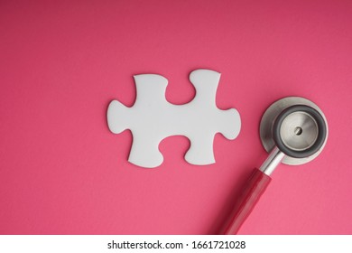 Stethoscope   white jigsaw puzzle pink background  Cancer awareness campaign concept  Copy space