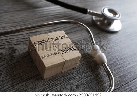 Stethoscope and wooden cubes with text AUTONOMY, BENEFICENCE, NON-MALEFICENCE, and JUSTICE. The four pillars of medical ethics concept. ストックフォト © 
