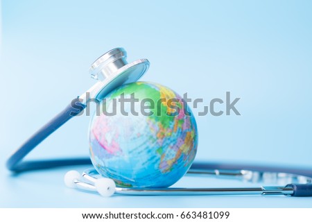 Stethoscope wrapped around globe on blue background. Save the wold, Global healthcare and Green Earth day concept.
