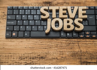 steve jobs - word made from wooden letters. lie on black modern keyboard. Wood table - natural material. empty copy space for inscription or others objects.