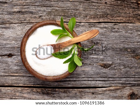Stevia rebaudiana, sweet leaf sugar substitute in wooden  bowl on wooden background.

