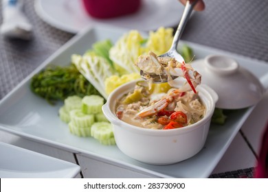 stew crab with coconut milk dip with fresh vegetables on white plates.