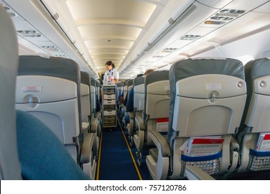 Steward Offers Food And Drinks To Economy Class Passengers On The Plane