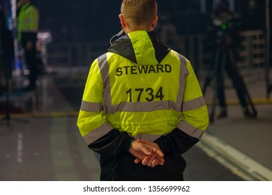 Steward Works At An Event, Back View