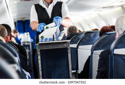 Stewardess Cleaning Garbage In Airplane After Lunch.