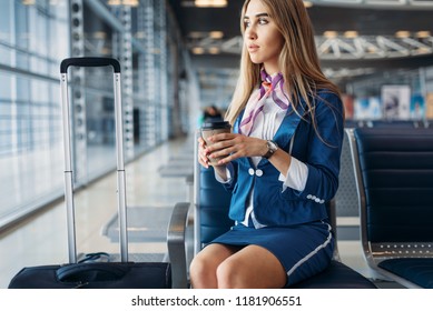 Stewardess With Coffee On Seat In Waiting Area